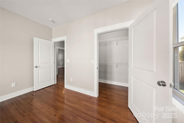 unfurnished bedroom with dark hardwood / wood-style flooring and a closet