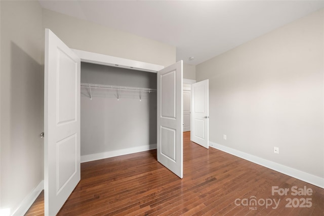 unfurnished bedroom featuring dark wood-type flooring and a closet