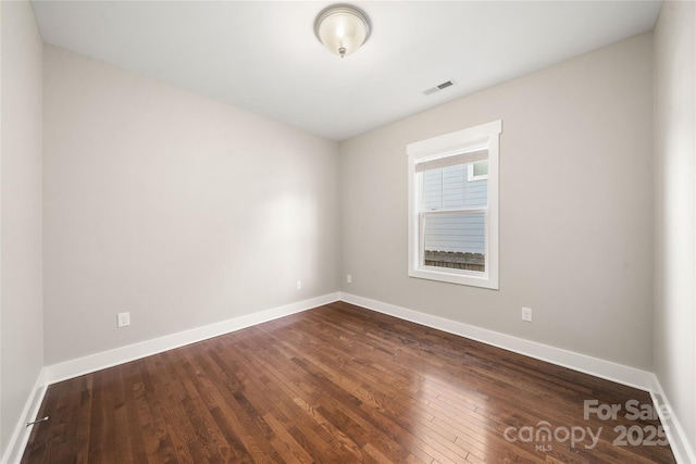 unfurnished room with dark hardwood / wood-style flooring