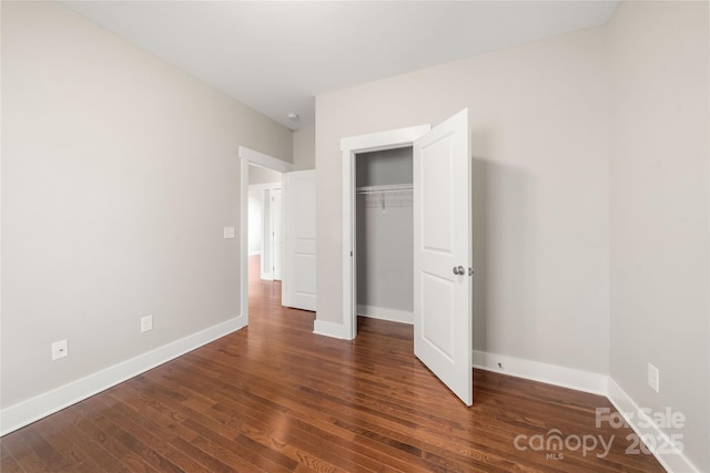 unfurnished bedroom featuring dark hardwood / wood-style flooring and a closet