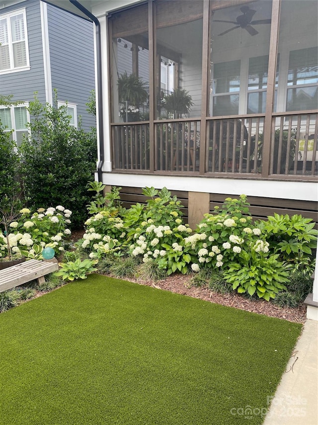 view of home's exterior with ceiling fan and a lawn