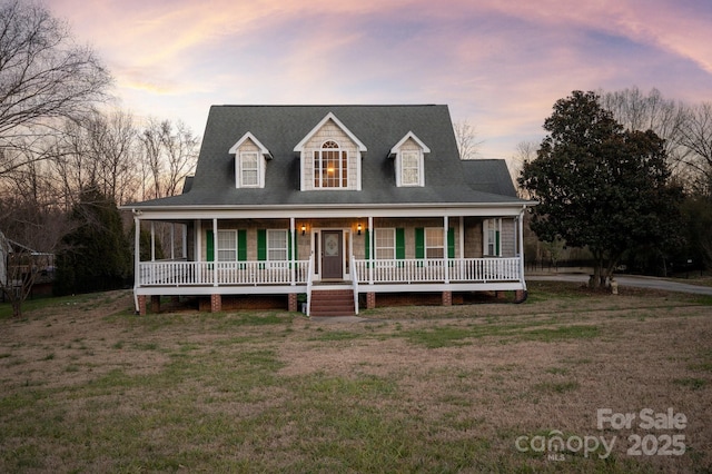 view of front of property with a porch and a lawn