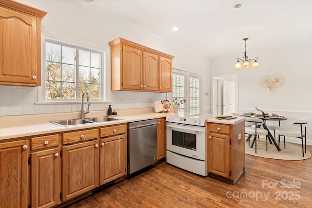 kitchen with sink, white range with electric cooktop, decorative light fixtures, stainless steel dishwasher, and kitchen peninsula