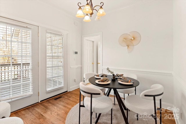 dining space featuring a notable chandelier and light wood-type flooring