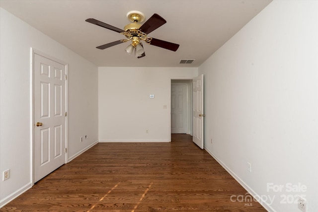 empty room with ceiling fan and dark hardwood / wood-style floors