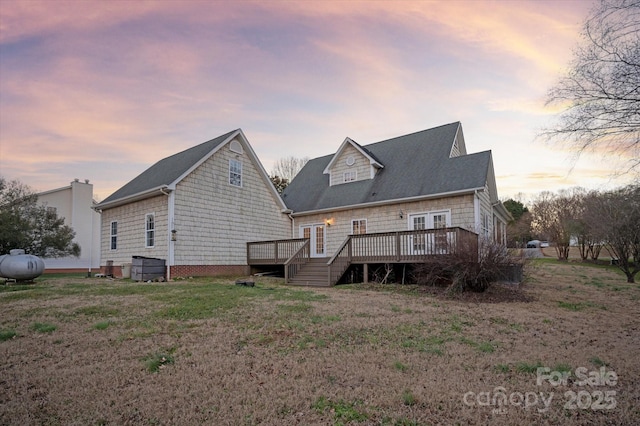 back house at dusk with a wooden deck