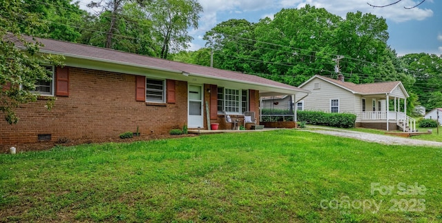 ranch-style home featuring covered porch and a front lawn