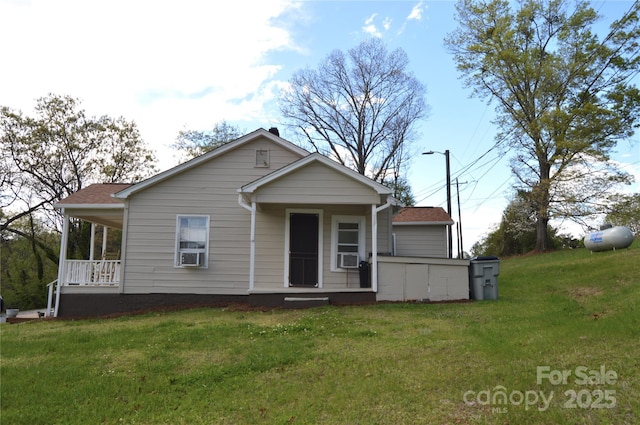 view of front of property featuring cooling unit, a front lawn, and covered porch