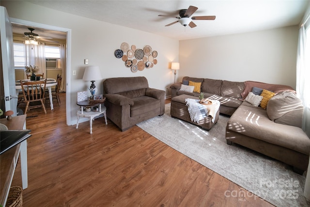 living room featuring ceiling fan and dark hardwood / wood-style flooring