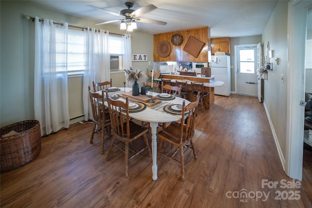 dining space featuring a baseboard radiator, plenty of natural light, dark wood-type flooring, and ceiling fan