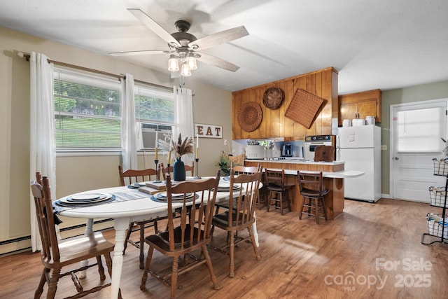 dining room featuring ceiling fan, cooling unit, and light hardwood / wood-style floors