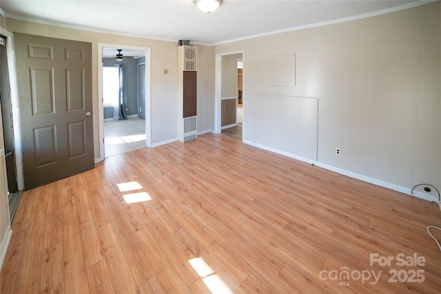 empty room featuring crown molding and light hardwood / wood-style flooring