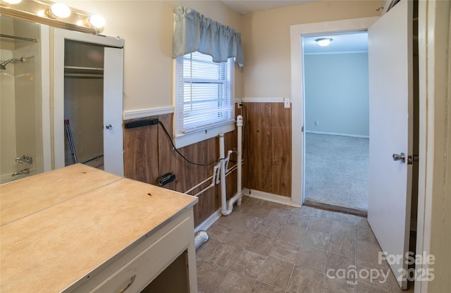 bathroom featuring walk in shower, vanity, and wooden walls