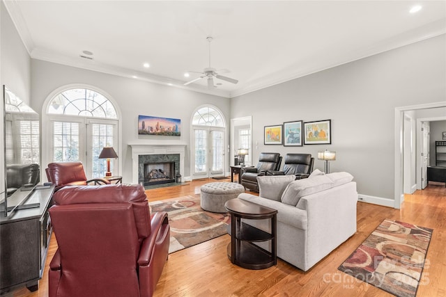 living room featuring crown molding, plenty of natural light, and light hardwood / wood-style flooring