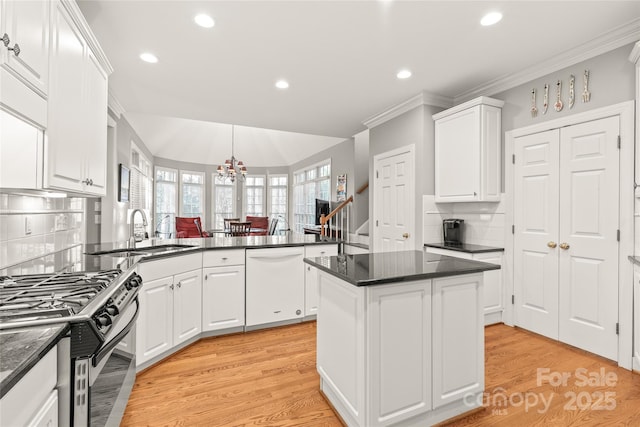 kitchen featuring sink, gas stove, a center island, dishwasher, and white cabinets