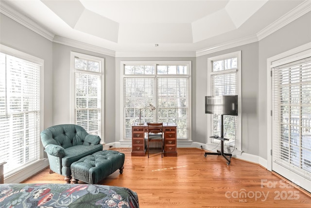 sitting room with hardwood / wood-style flooring, a raised ceiling, a healthy amount of sunlight, and ornamental molding