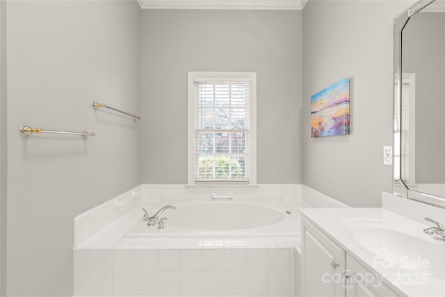 bathroom featuring tiled tub and vanity