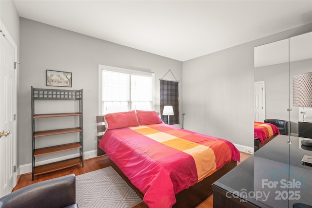 bedroom with dark wood-type flooring and a closet