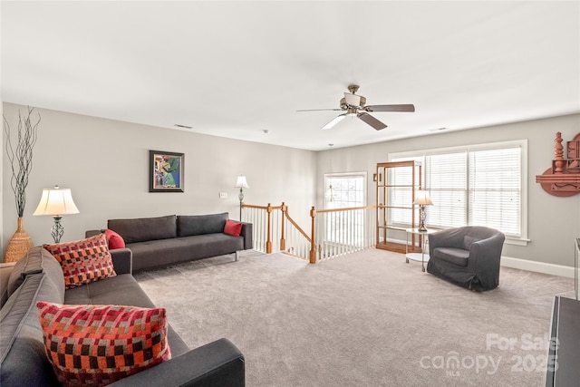 carpeted living room with ceiling fan