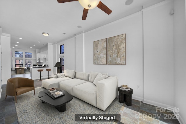 living area with recessed lighting, stone tile flooring, ceiling fan, and baseboards