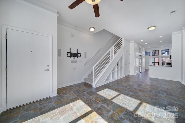 foyer entrance with visible vents, a ceiling fan, stone finish flooring, baseboards, and stairs