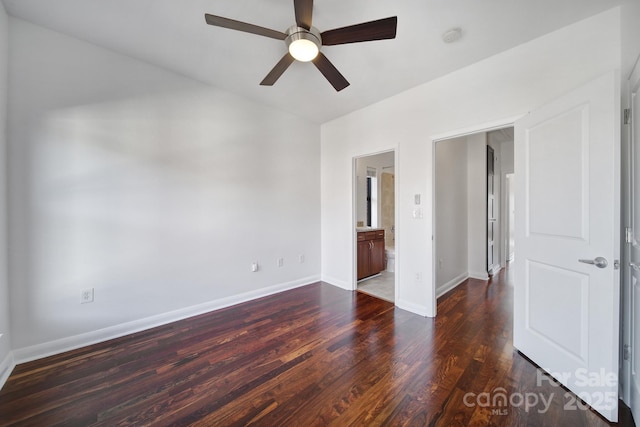 unfurnished bedroom with ceiling fan, wood finished floors, connected bathroom, and baseboards