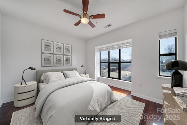 bedroom with wood finished floors, visible vents, baseboards, and multiple windows