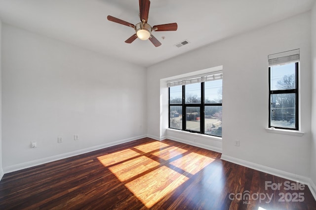 spare room featuring a ceiling fan, wood finished floors, visible vents, and baseboards