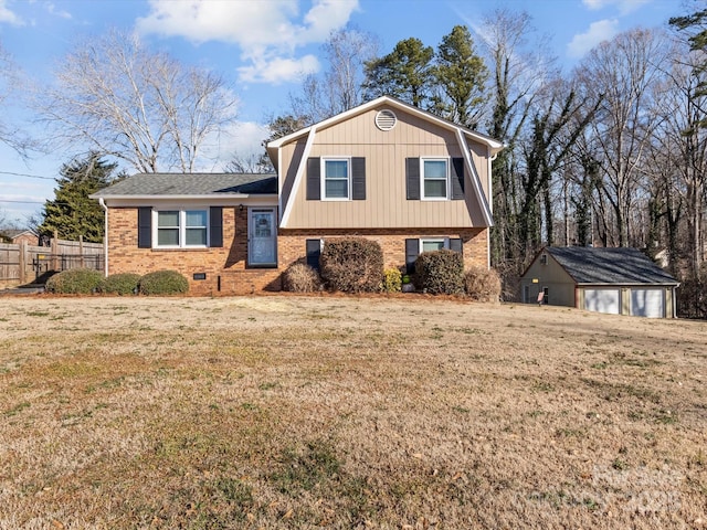 split level home featuring a garage, an outdoor structure, and a front lawn