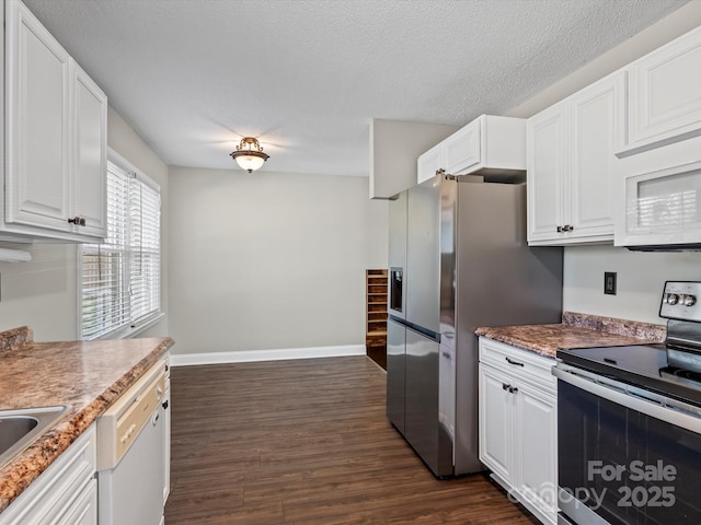 kitchen with a textured ceiling, dark wood-type flooring, white cabinets, and appliances with stainless steel finishes