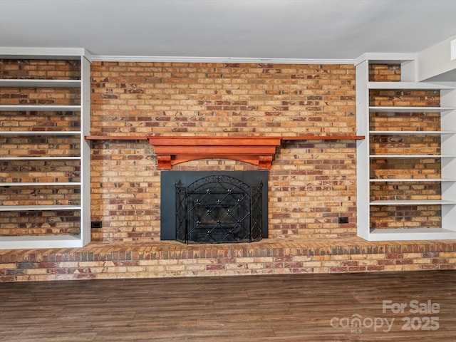 interior details with a brick fireplace, wood-type flooring, and ornamental molding