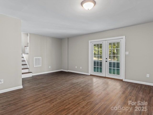 empty room with dark hardwood / wood-style flooring and french doors