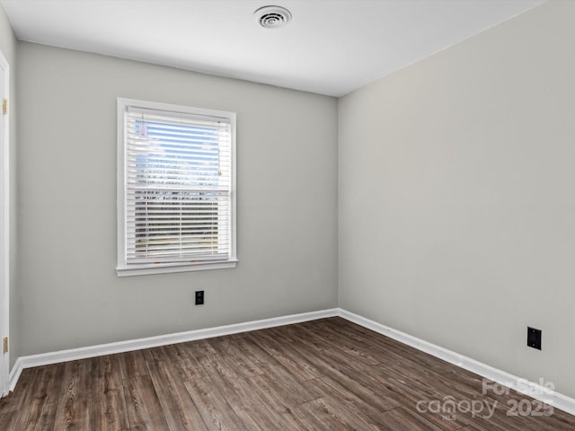 unfurnished room with dark wood-type flooring