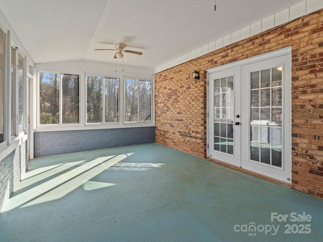 unfurnished sunroom with vaulted ceiling, a wealth of natural light, ceiling fan, and french doors