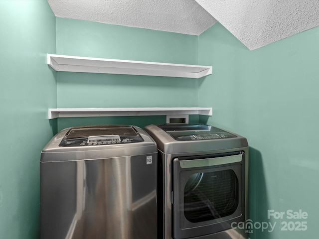 washroom featuring washing machine and dryer and a textured ceiling