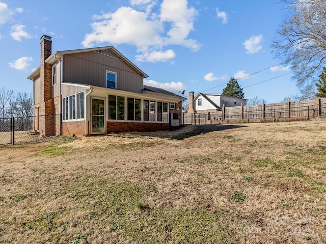 back of house featuring a sunroom and a lawn