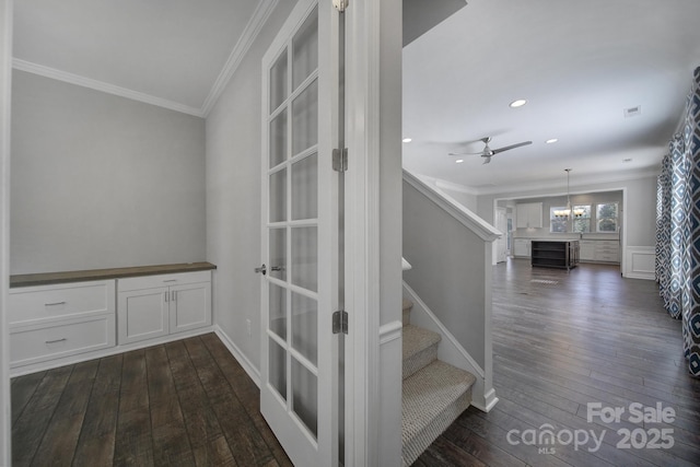 stairs featuring wood-type flooring, ceiling fan, and crown molding