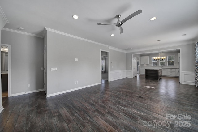 unfurnished living room featuring ornamental molding, ceiling fan with notable chandelier, and dark hardwood / wood-style flooring