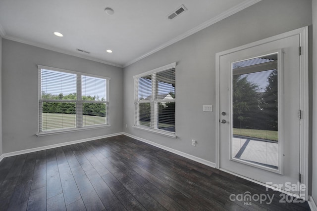 empty room featuring dark wood-type flooring and ornamental molding