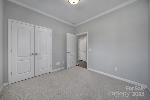 unfurnished bedroom featuring ornamental molding, carpet flooring, and a closet