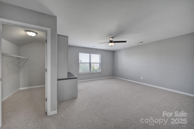 interior space featuring light carpet and ceiling fan