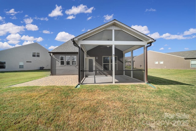 back of house featuring a lawn, a sunroom, and a patio