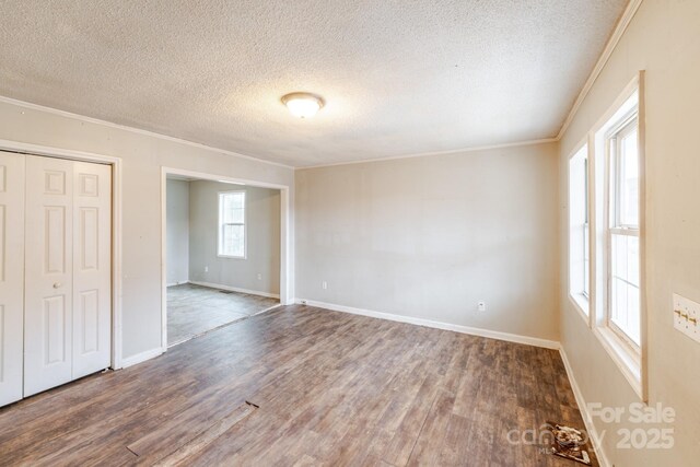 spare room with wood-type flooring, ornamental molding, and a textured ceiling