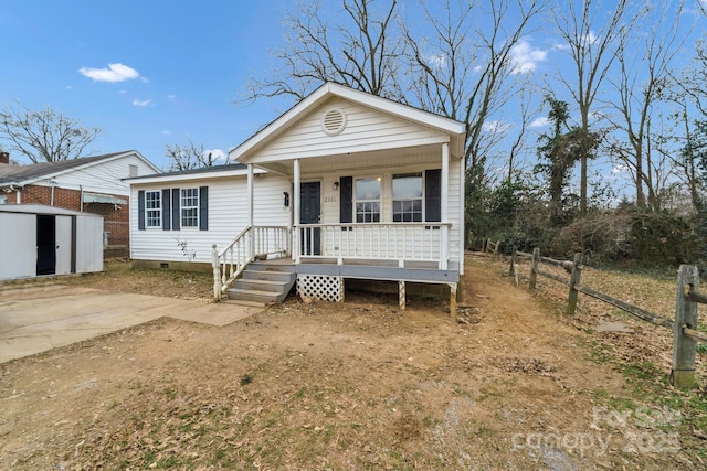 view of front of home featuring a porch and a storage unit