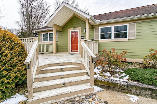 view of front of property with roof with shingles and a wooden deck