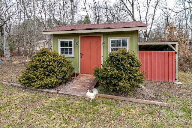 view of outbuilding with fence and an outdoor structure