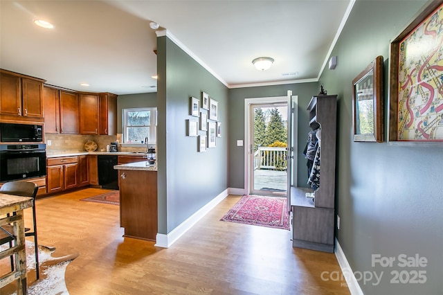 interior space with tasteful backsplash, ornamental molding, light wood-style flooring, and black appliances