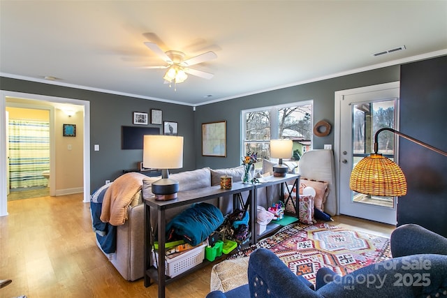 interior space with ornamental molding, wood finished floors, and a healthy amount of sunlight