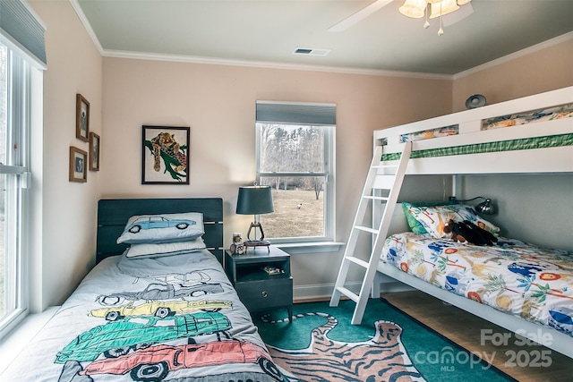 bedroom with ceiling fan, baseboards, visible vents, and crown molding