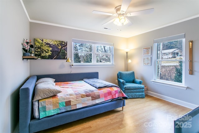 bedroom with visible vents, ornamental molding, ceiling fan, wood finished floors, and baseboards